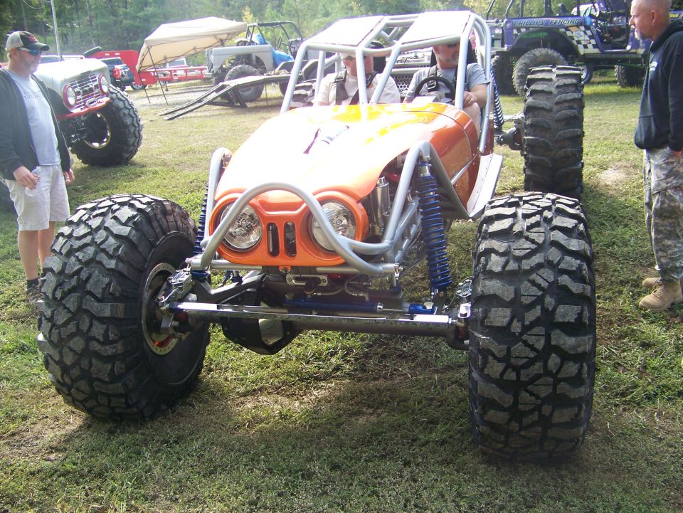 Orange buggy with oversized tires and roll cage