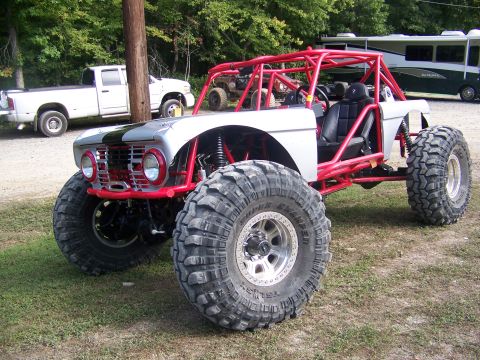 2001 Dodge 1500 - This heavily modified buggy features a custom roll cage and oversized tires, with other vehicles visible in the background.