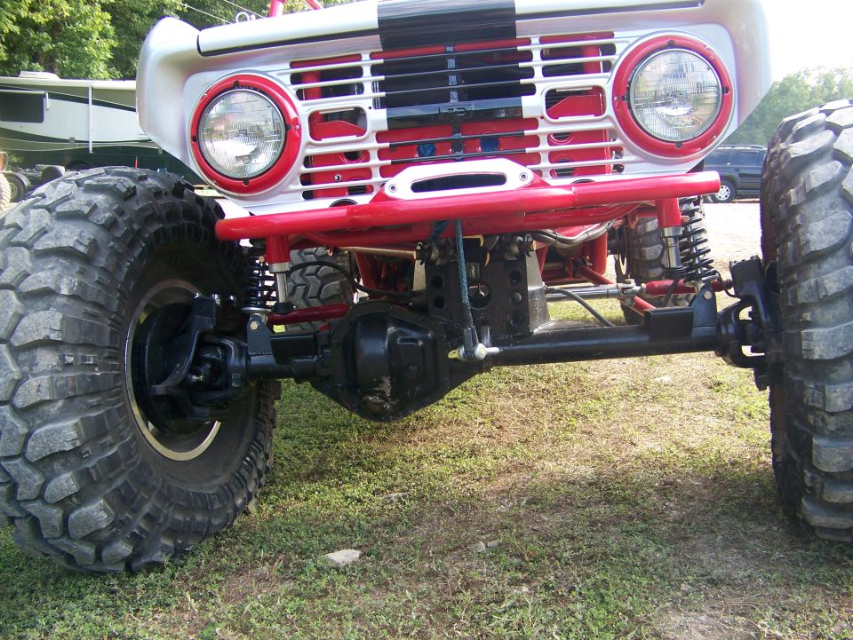 Off-road vehicle front axle and large tires, with red and white grille