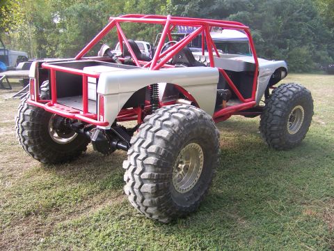 2001 Dodge 1500 - Custom off-road buggy features a prominent red roll cage and oversized tires, modified for extreme terrain.