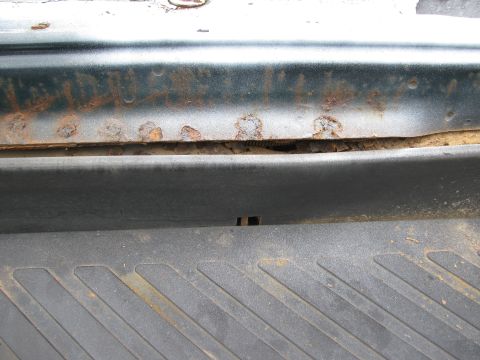 1992 Ford Bronco - This photo shows significant rust damage on a vehicle's lower body panel, indicating potential structural issues.