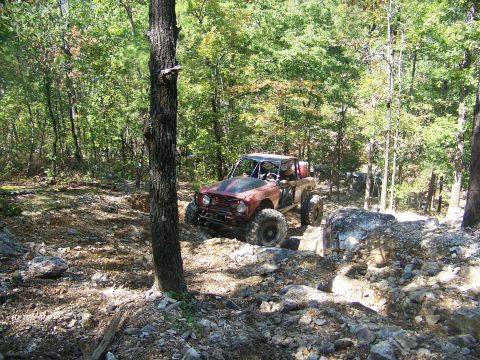 2001 Dodge 1500 - Off-road vehicle tackling a challenging rocky path in a wooded area.