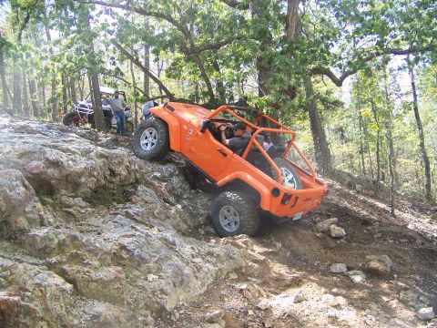 2001 Dodge 1500 - Two off-road vehicles navigate a challenging rocky terrain on a wooded hillside.