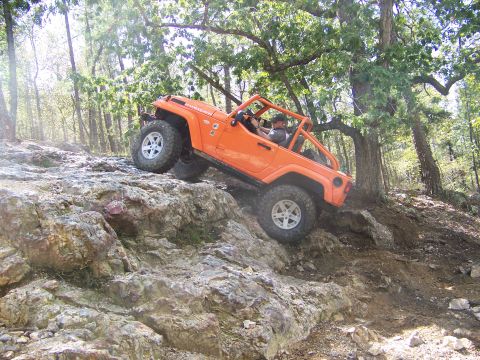 2001 Dodge 1500 - Jeep Wrangler Rubicon navigates a challenging rocky trail in a forest setting.