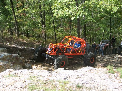 2001 Dodge 1500 - Multiple off-road vehicles navigate a challenging rocky terrain in a wooded area.