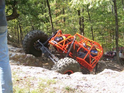 2001 Dodge 1500 - An orange off-road buggy navigates a rocky trail, with another vehicle visible behind it.