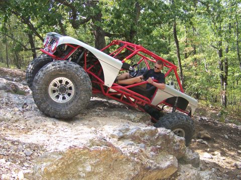 2001 Dodge 1500 - A custom-built buggy is shown tackling a challenging rocky trail in a wooded area.