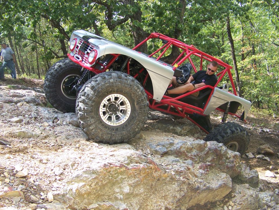 Silver off-road buggy with red roll cage on rocky terrain