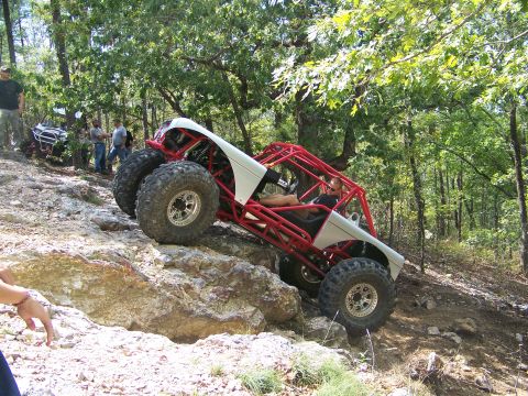 2001 Dodge 1500 - A custom off-road buggy navigates a challenging rocky trail, with another vehicle and spectators in the background.