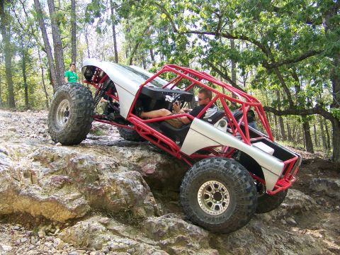 2001 Dodge 1500 - A custom-built off-road buggy navigates a challenging rocky trail with two people inside.