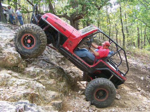 2001 Dodge 1500 - A modified Jeep navigates a steep, rocky incline with spectators watching from the side.