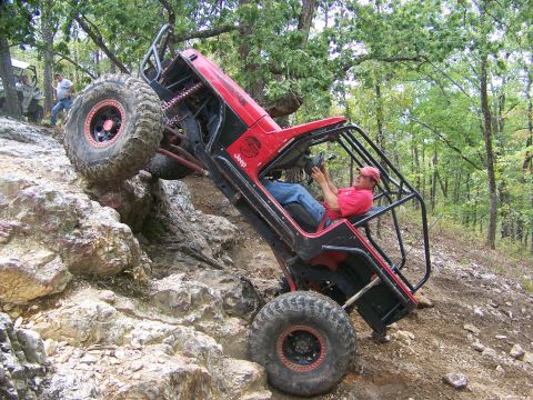 2001 Dodge 1500 - A modified Jeep navigates a steep, rocky incline on an off-road trail.
