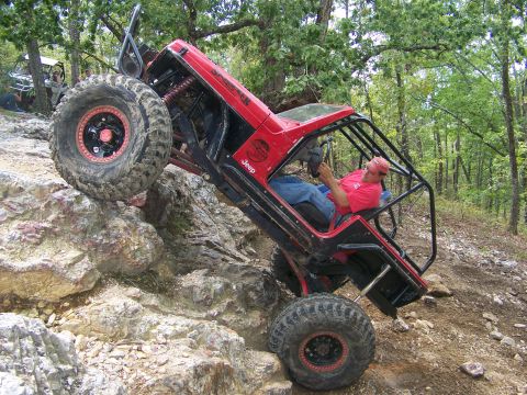 2001 Dodge 1500 - A heavily modified Jeep navigates a rocky trail, demonstrating extreme off-road capability.