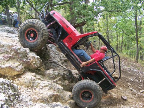 2001 Dodge 1500 - A heavily modified Jeep navigates a challenging rocky terrain, demonstrating extreme off-road capability.
