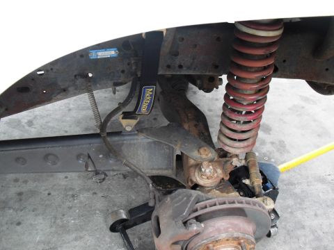 1986 Ford Bronco - Close-up view of vehicle suspension components, including a coil spring and brake assembly.
