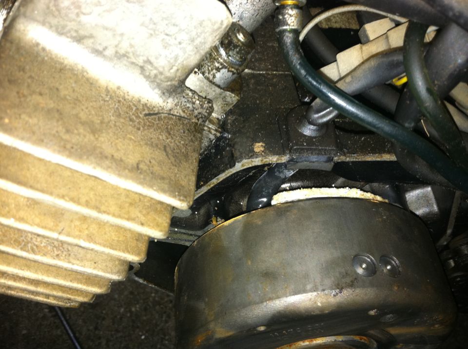 Close-up of a moped's engine, showing the flywheel and part of the cylinder