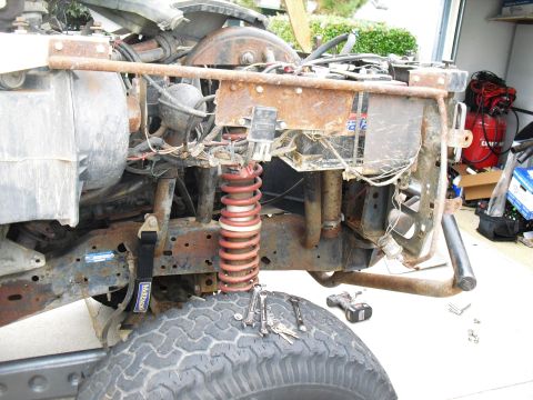 1986 Ford Bronco - The front end of a 1986 Ford Bronco is shown disassembled, with tools laid out on the tire.
