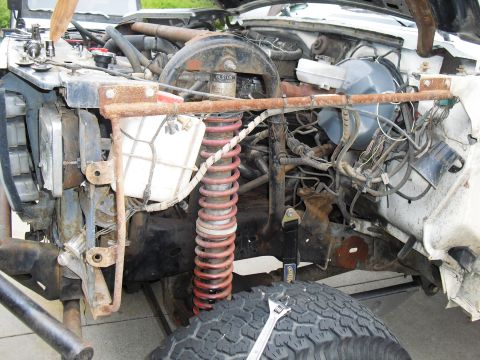 1986 Ford Bronco - The engine bay of a heavily modified off-road vehicle shows extensive modifications and wear.