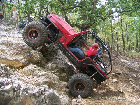 2001 Dodge 1500 - A modified Jeep Wrangler navigates a challenging rocky trail with spectators observing the difficult climb.