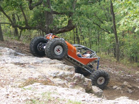 2001 Dodge 1500 - A custom off-road buggy navigates a challenging rocky terrain with large, aggressive tires.