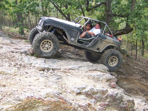 2001 Dodge 1500 - An off-road vehicle navigates a challenging rocky terrain with two occupants inside.