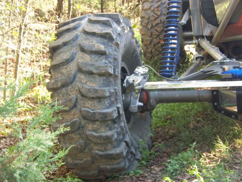2001 Dodge 1500 - Close-up view of the suspension and massive tire of a modified off-road vehicle.