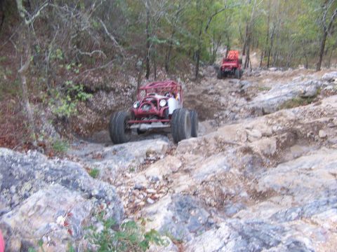 2001 Dodge 1500 - Two custom off-road buggies navigate a challenging rocky terrain on a wooded trail.