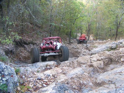 2001 Dodge 1500 - Custom off-road vehicles tackle a challenging rocky path through a forest.