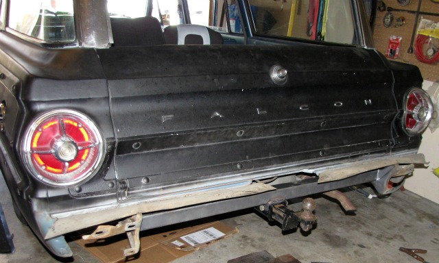 Rear of black 1965 Ford Falcon station wagon with trailer hitch and round taillights