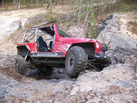 2001 Dodge 1500 - Modified Jeep Wrangler tackling a challenging off-road course with large rocks.