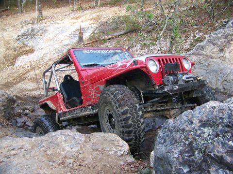 2001 Dodge 1500 - Modified Jeep Wrangler tackling a challenging off-road course with large rocks and steep inclines.