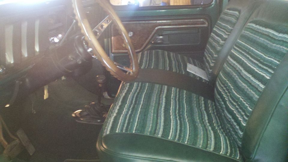 1978 Ford Bronco interior showing striped seats, wood-grain trim, and steering wheel