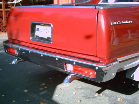 1979 Chevrolet El Camino - The rear of a red pickup truck is shown, a chrome bumper and dual exhaust pipes.