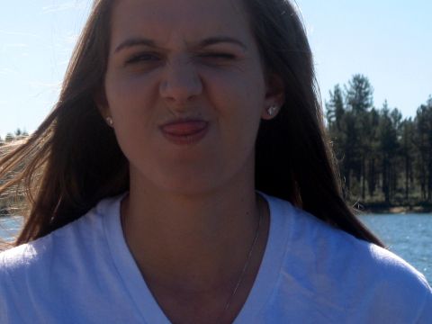 1996 Ford Bronco - A woman playfully makes a funny face while standing outdoors near a body of water.