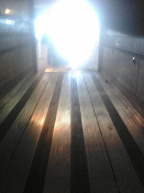 1988 Ford Bronco - Looking out from the wooden floor of a truck bed towards a bright light source.