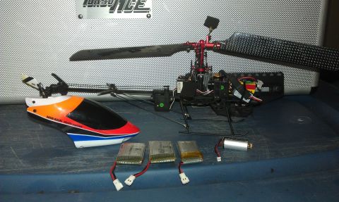 1992 Ford Ranger - Components of a remote control helicopter are laid out, including the body, batteries, and motor.
