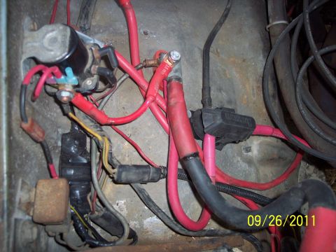 1973 Ford F-250 - A tangle of red and black wires, along with a starter solenoid and fuse box, are visible in this close-up shot of vehicle electrical compon…