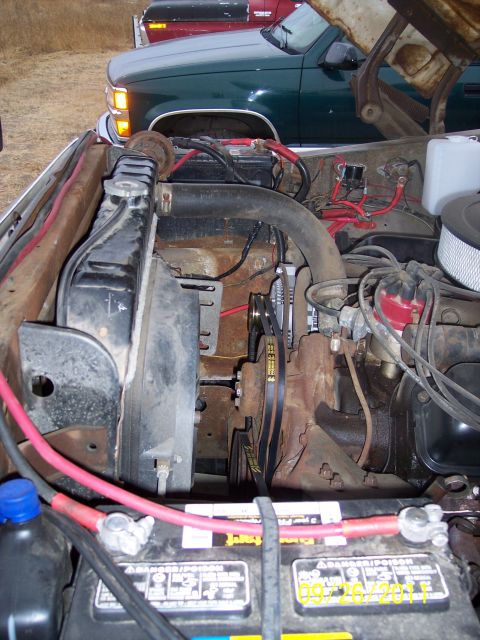 1973 Ford F-250 - Close-up view of a truck's engine bay, with other vehicles partially visible behind it.