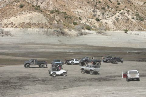 1991 Ford Bronco - Multiple off-road vehicles gathered in a barren, mountainous terrain.