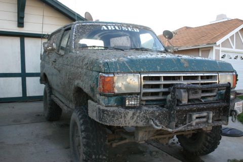 1991 Ford Bronco - This 1991 Ford Bronco is heavily covered in mud, suggesting recent off-road use.