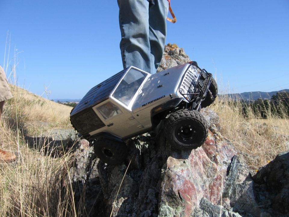 RC rock crawler on rocks, person standing nearby