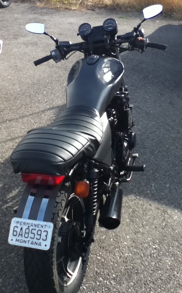 Black motorcycle with a ribbed seat and Montana license plate 6A8593