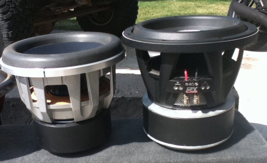Two car subwoofers, one silver and one black, with visible wiring and branding