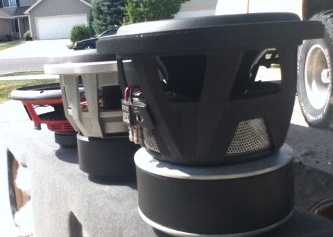 2006 Ford E350 - Multiple subwoofers are displayed outdoors, with a residential area visible behind them.
