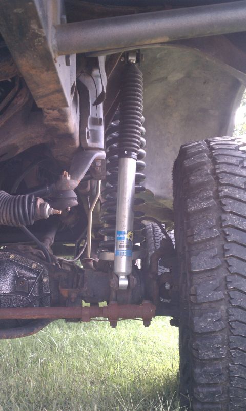 1979 Ford Bronco - Undercarriage view of a vehicle's suspension components, including a shock absorber and tire.