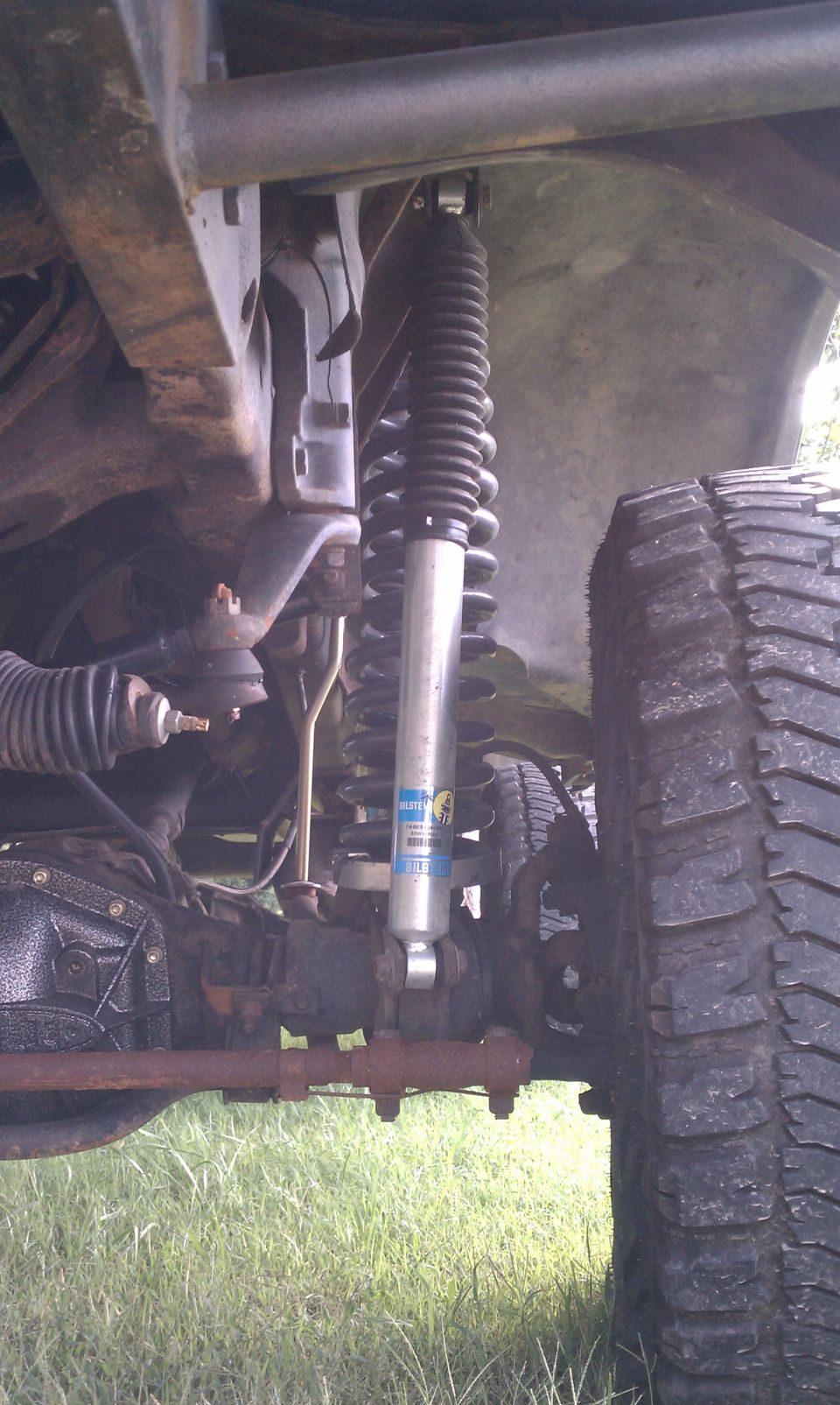 Close-up of a vehicle's suspension system with a Bilstein shock absorber and a large tire