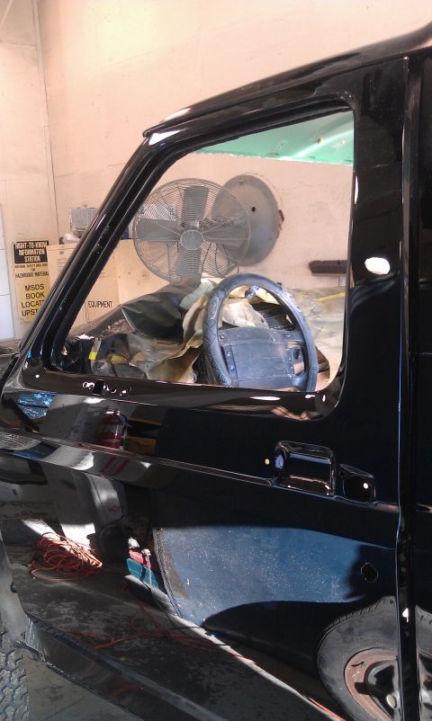 1995 Ford Bronco - Interior view of a black vehicle, showing the steering wheel and a fan mounted on the wall.