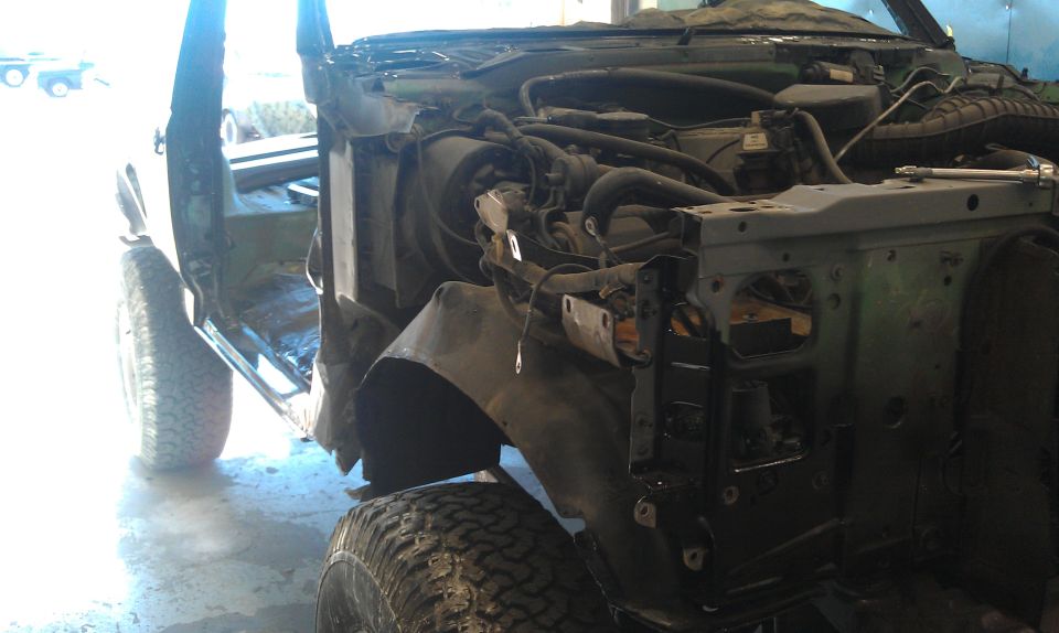 1995 Ford Bronco disassembled, showing engine bay and front fender removed