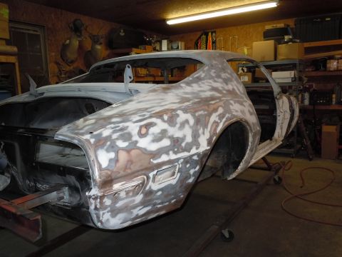 1973 Pontiac Trans Am - A 1973 Pontiac Trans Am body is shown in primer, undergoing restoration work in a garage.