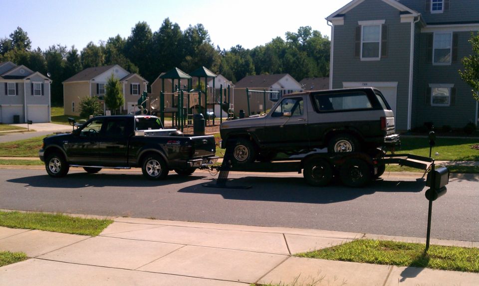 Two-tone 1985 Ford Bronco on trailer, side view